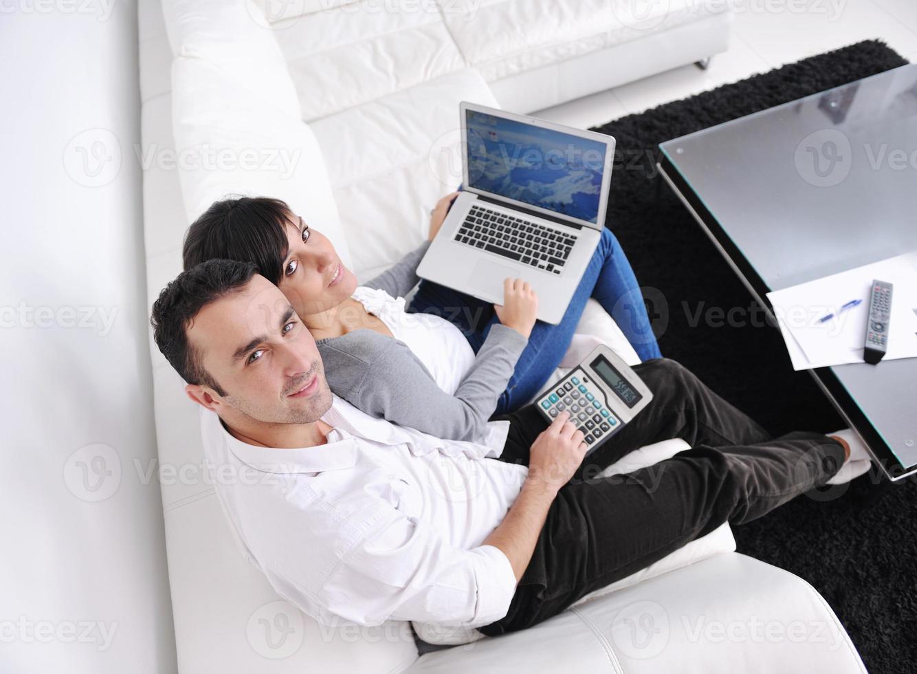 joyful couple relax and work on laptop computer at modern home photo