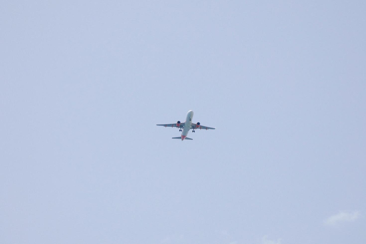 commercial aircraft flying under blue skies and arriving at the airport photo