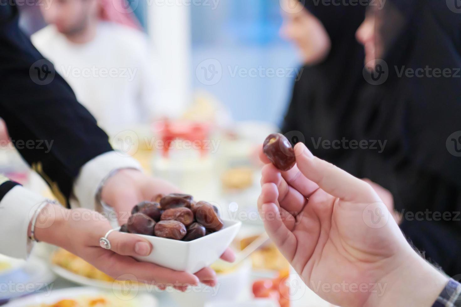 Muslim family having Iftar dinner eating dates to break feast photo