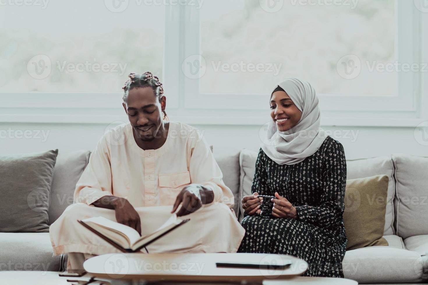 African Muslim couple at home in Ramadan reading Quran holly Islam book. photo