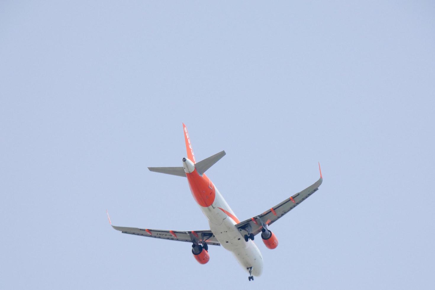 commercial aircraft flying under blue skies and arriving at the airport photo