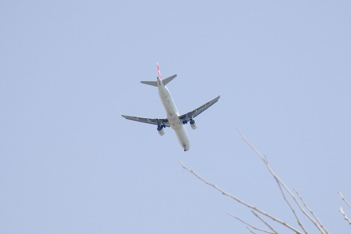commercial aircraft flying under blue skies and arriving at the airport photo