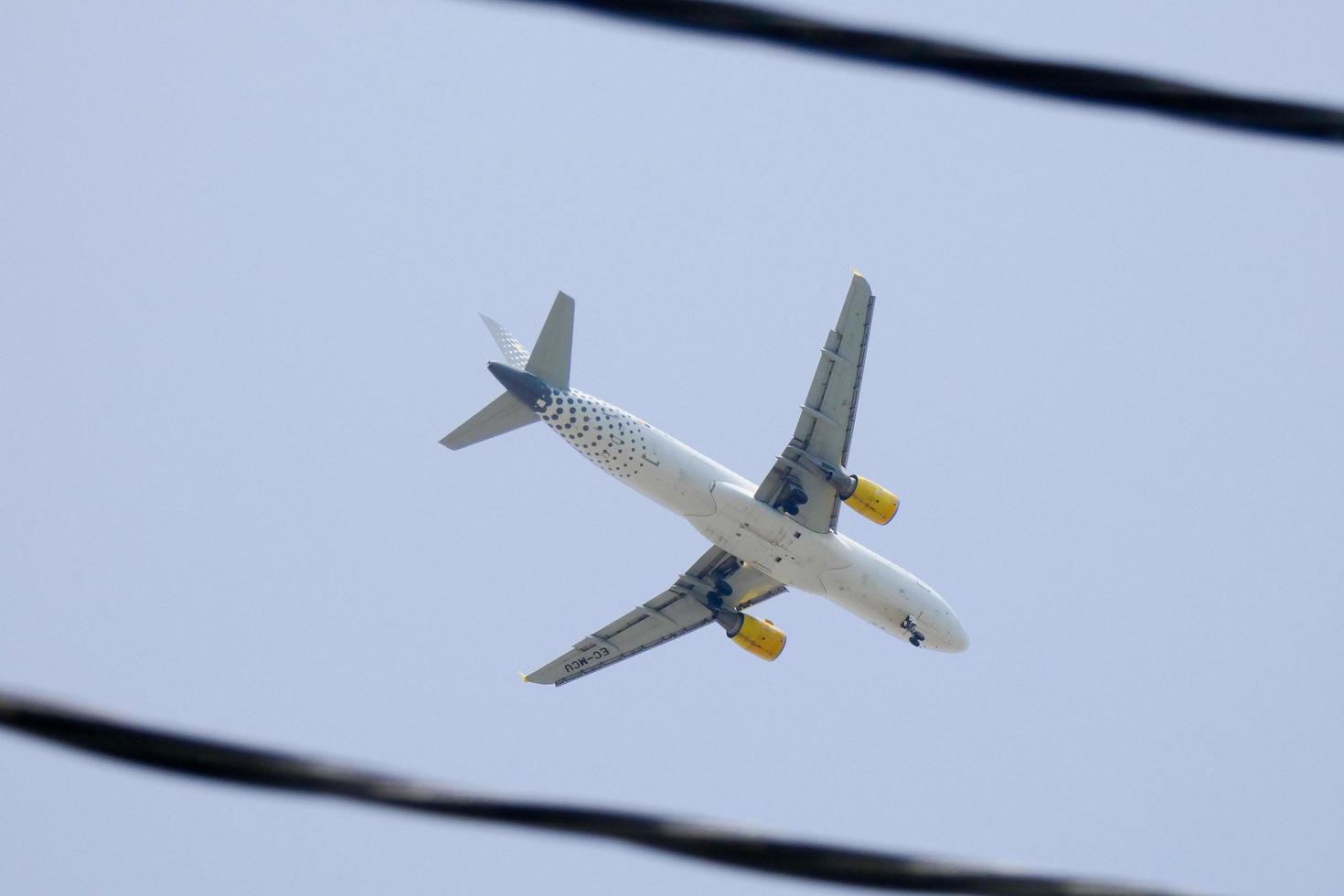 commercial aircraft flying under blue skies and arriving at the airport photo