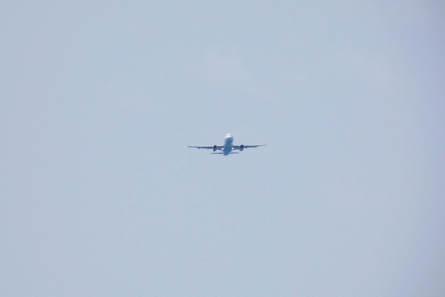 commercial aircraft flying under blue skies and arriving at the airport photo