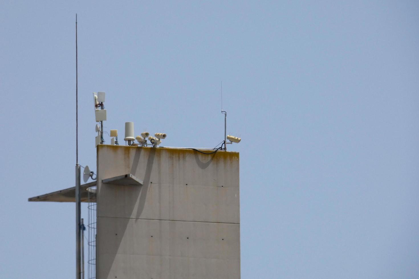security cameras and telephone and radio antennas photo