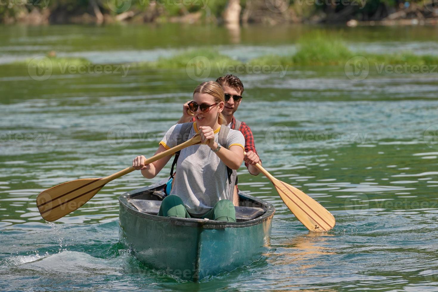 friends are canoeing in a wild river photo