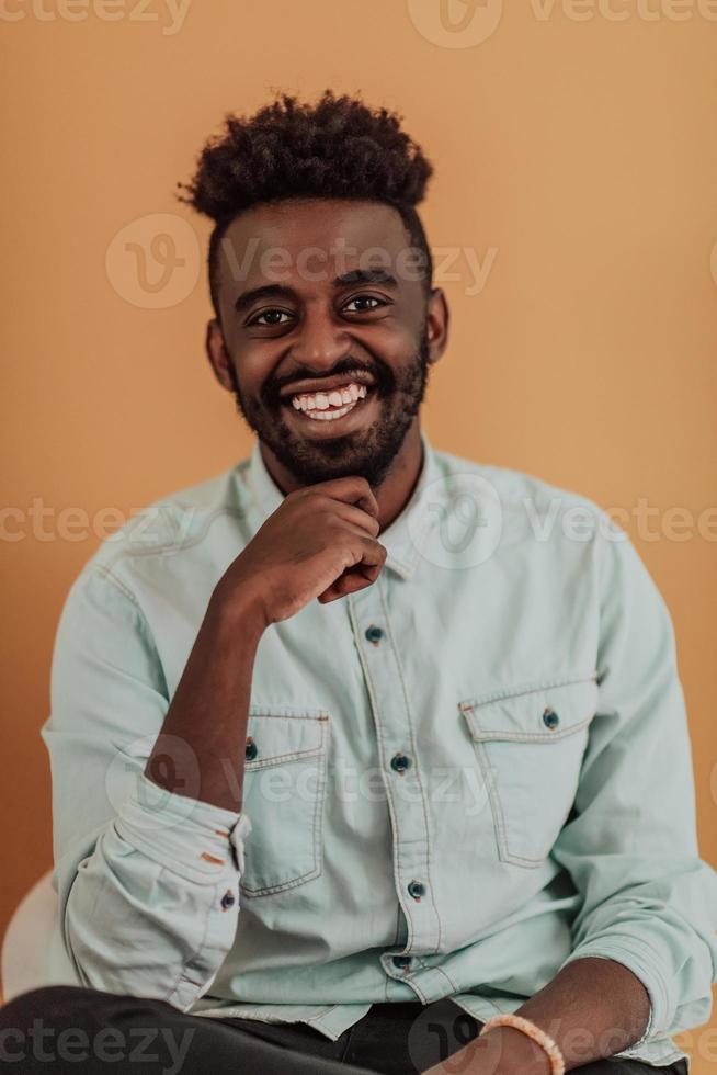 estudiante africano que usa una computadora portátil para estudiar y hacer conexiones de negocios fondo amarillo foto