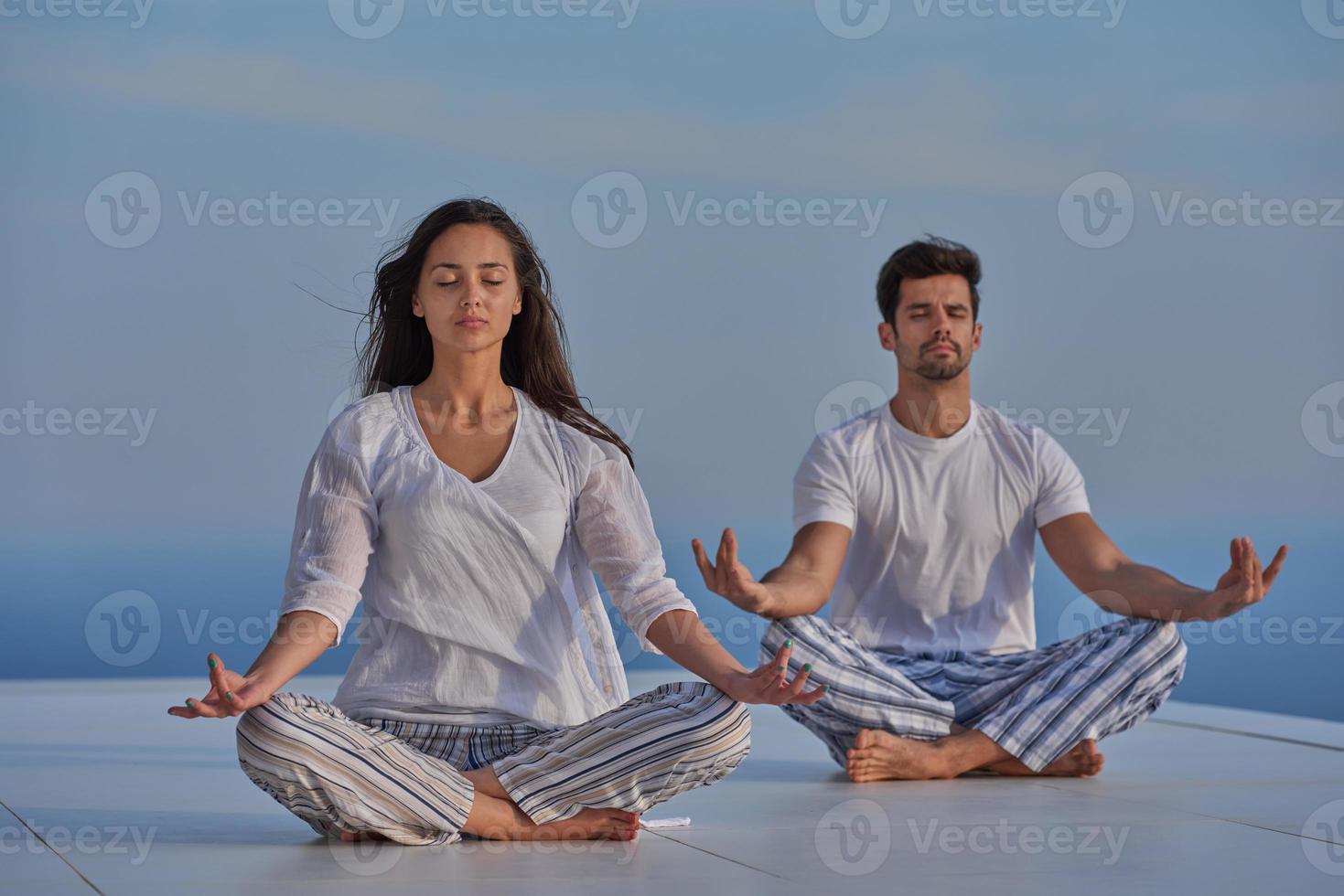 young couple practicing yoga photo