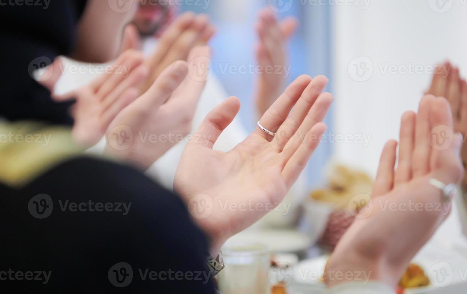 traditional muslim family praying before iftar dinner photo