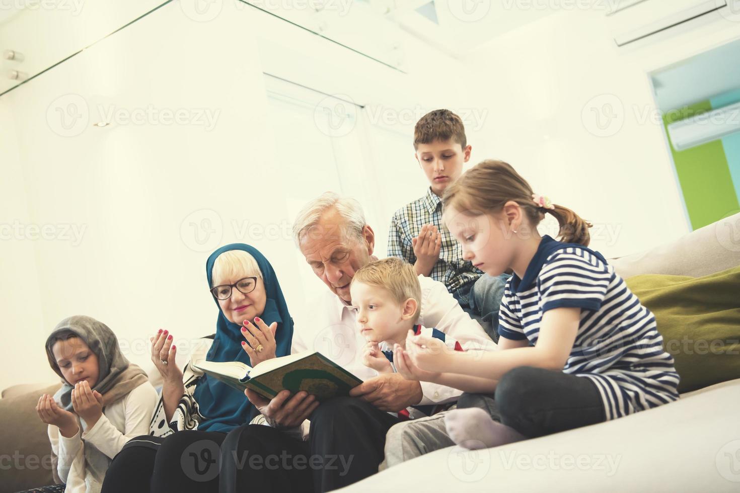 modern muslim grandparents with grandchildren reading Quran photo