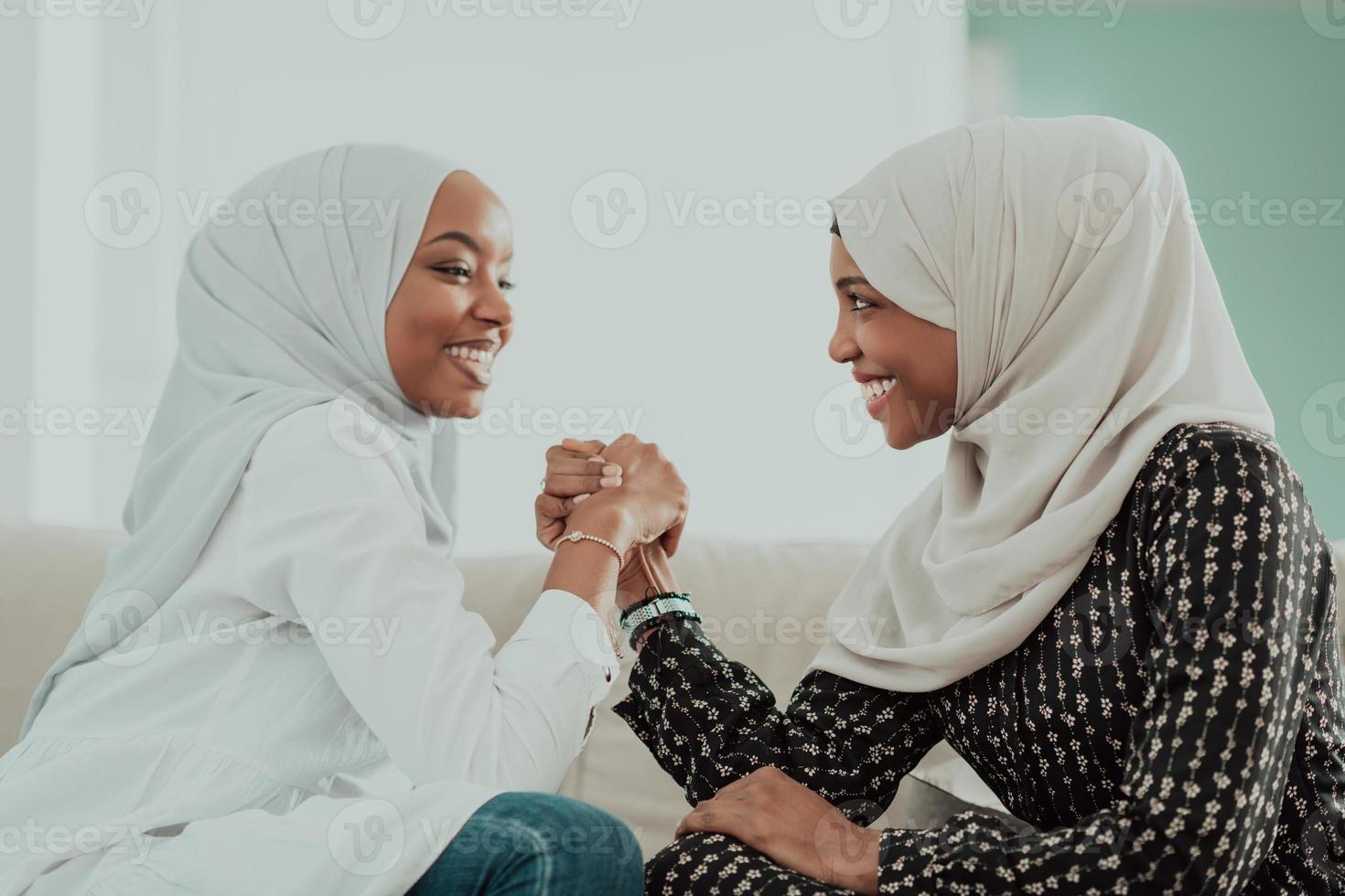 African woman arm wrestling conflict concept, disagreement and confrontation wearing traditional islamic hijab clothes. Selective focus photo