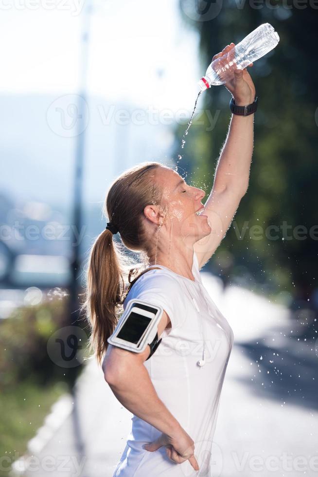 woman drinking  water after  jogging photo