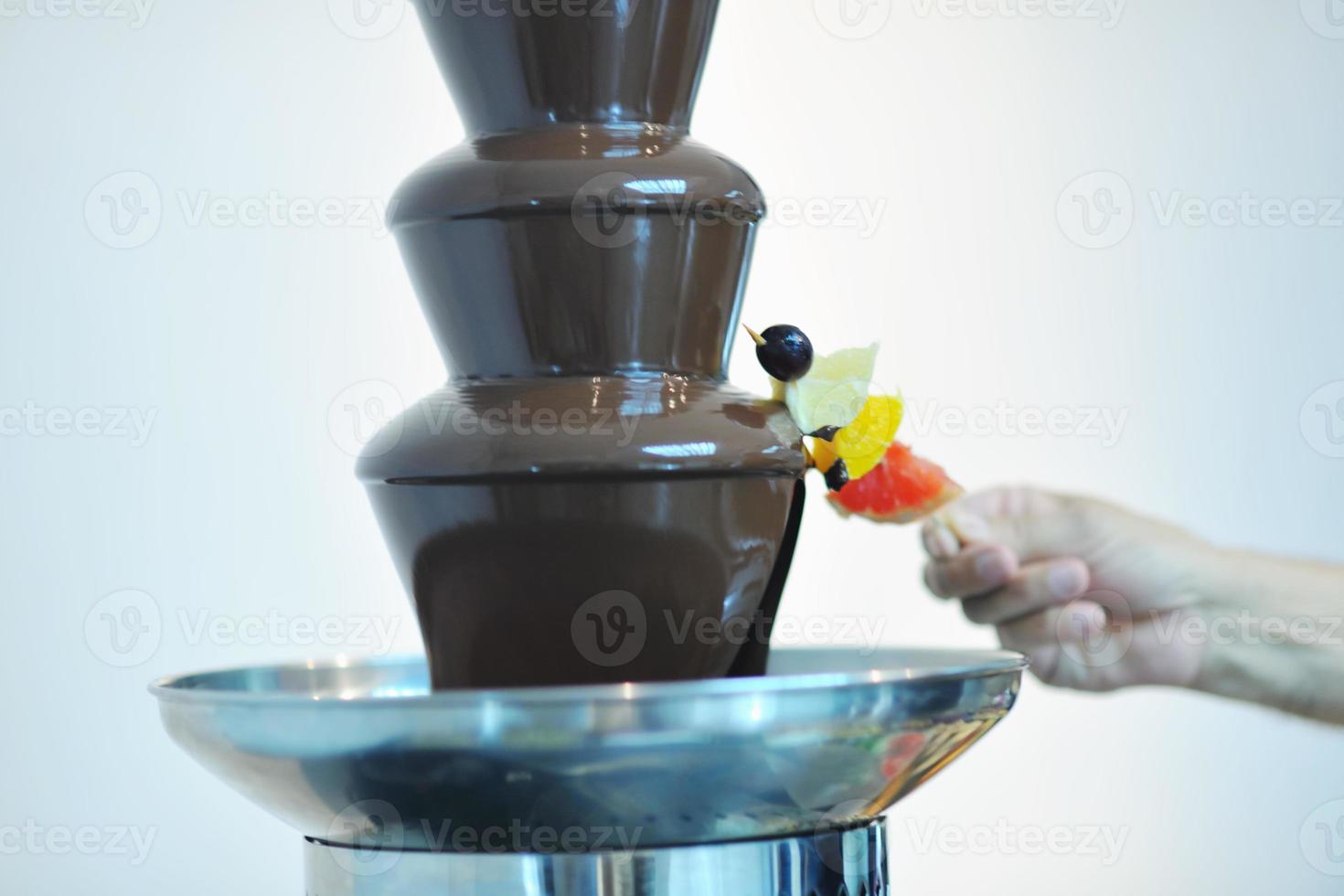 liquid chocolate fountain and fresh fruits on stick photo