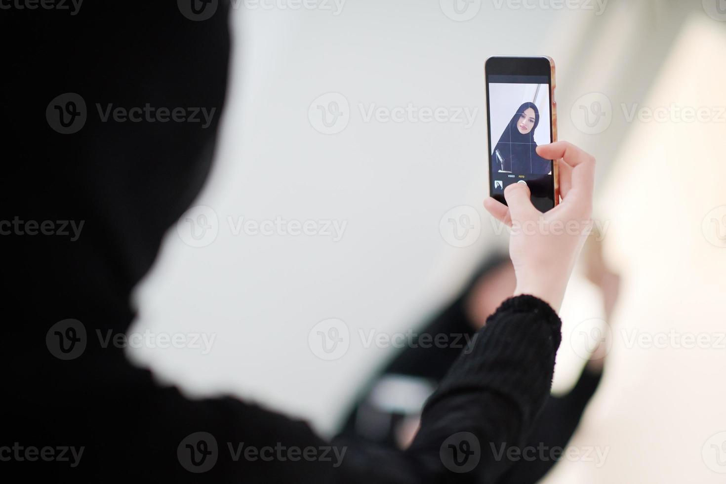 muslim woman taking selfie picture at home photo