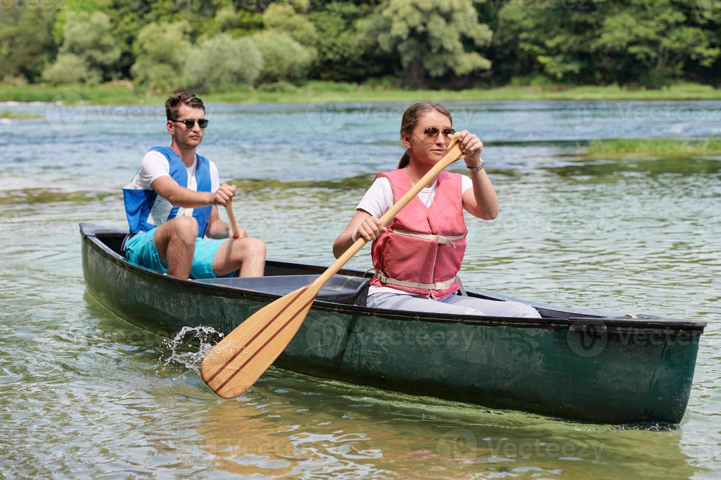 friends are canoeing in a wild river photo