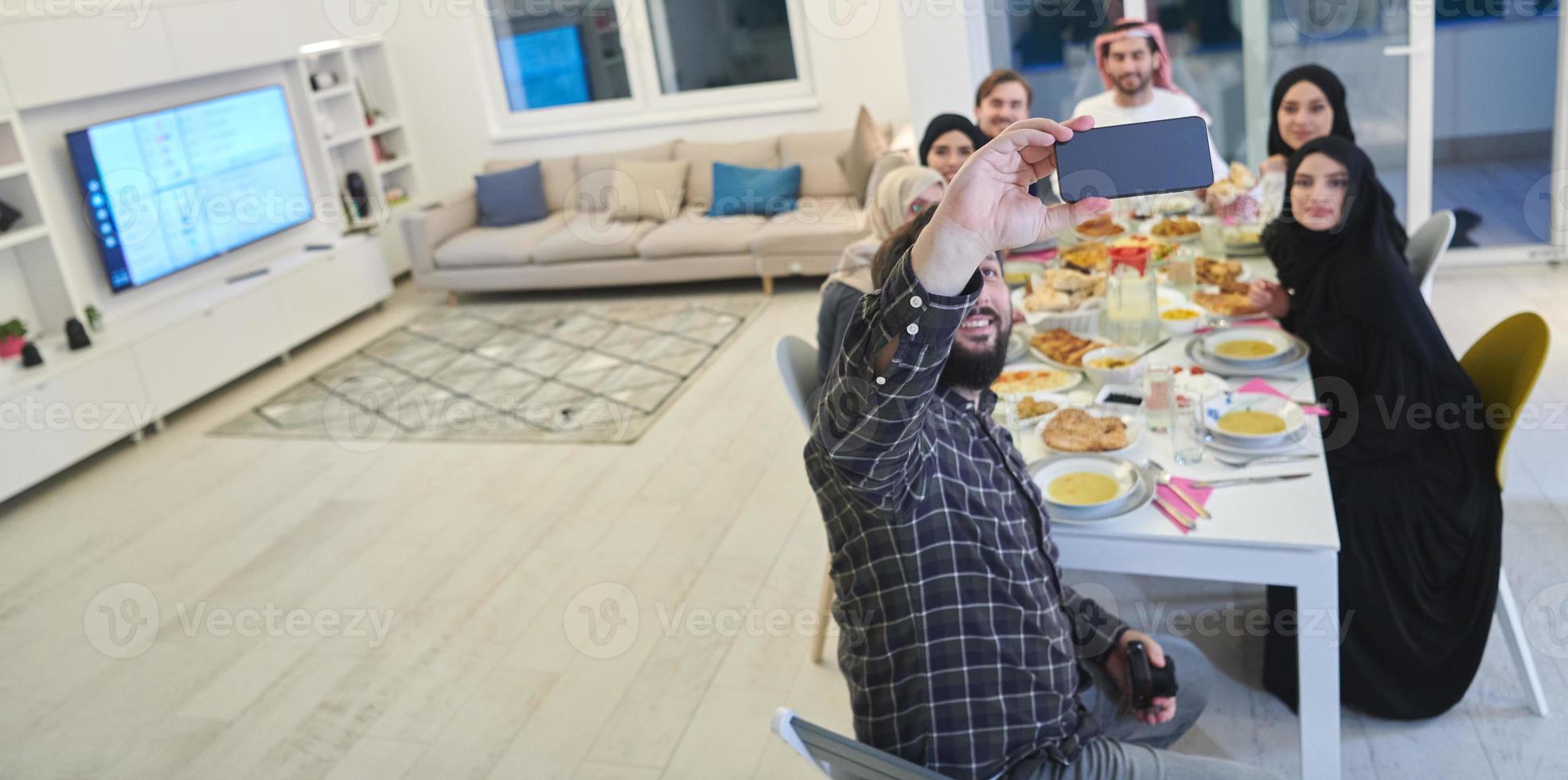 Muslim family taking selfie while having iftar together during Ramadan photo
