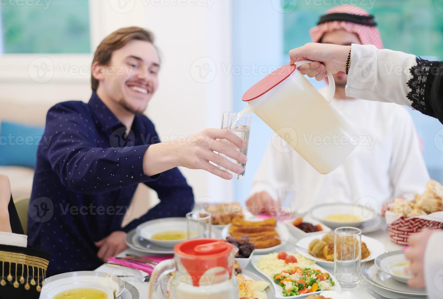 Muslim family having Iftar dinner drinking water to break feast photo