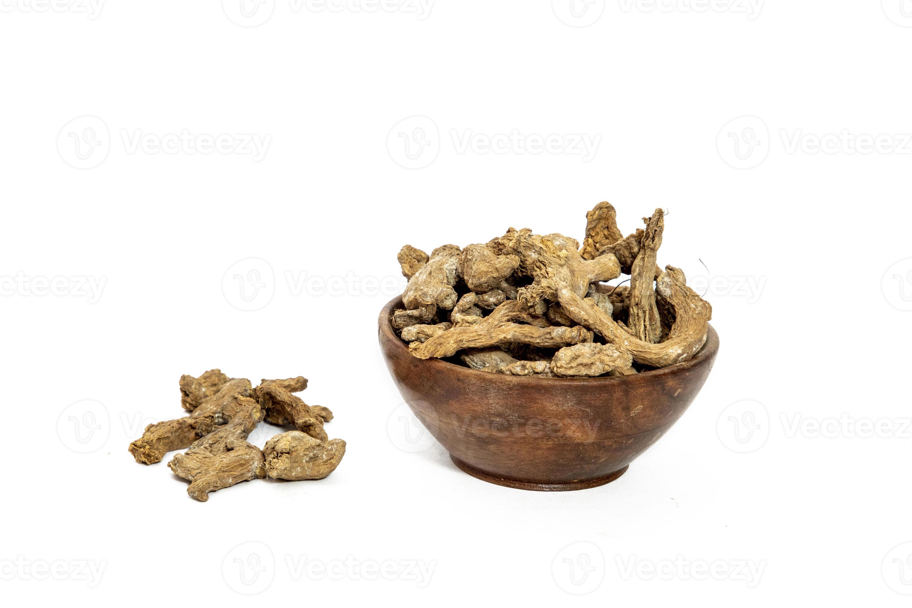 Dry ginger slices or zingiber officinale in bowl isolated on white