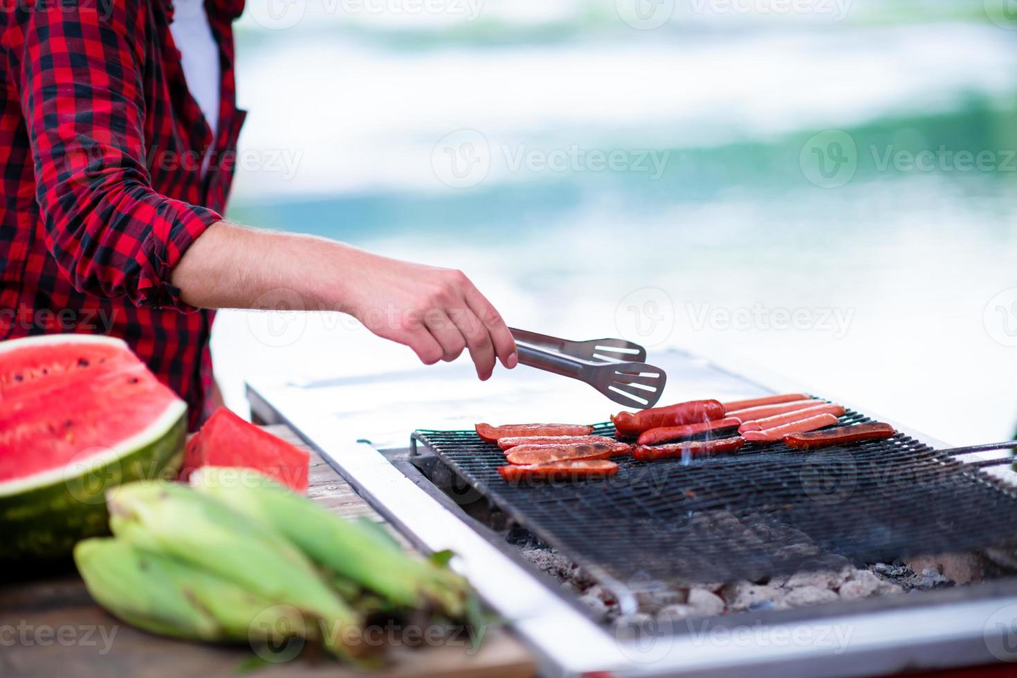 Man cooking tasty food on barbecue grill photo