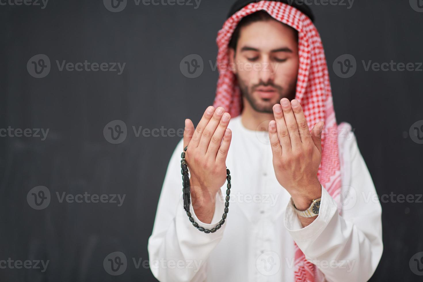 Arab man in traditional clothes praying to God or making dua photo