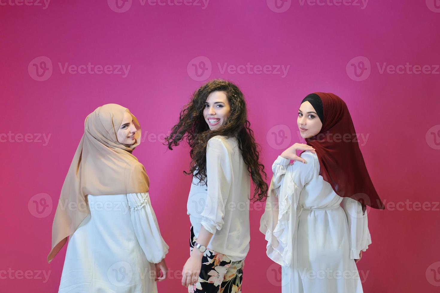 Young muslim women posing on pink background photo