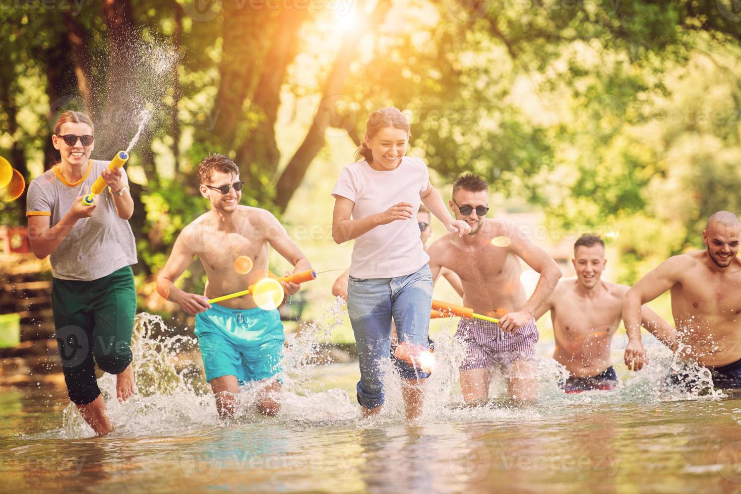 grupo de amigos felices divirtiéndose en el río foto