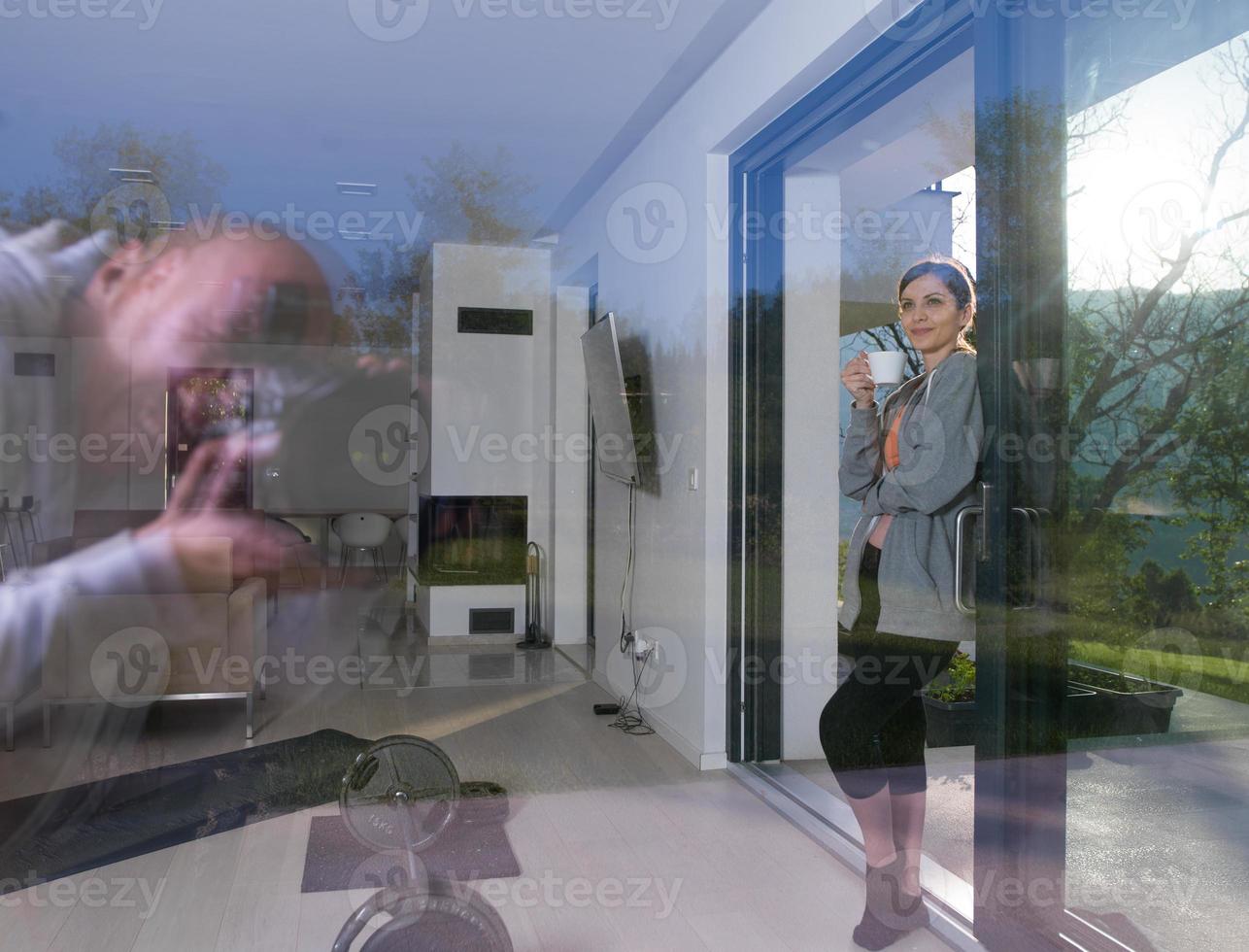 mujer tomando café frente a su villa de lujo foto