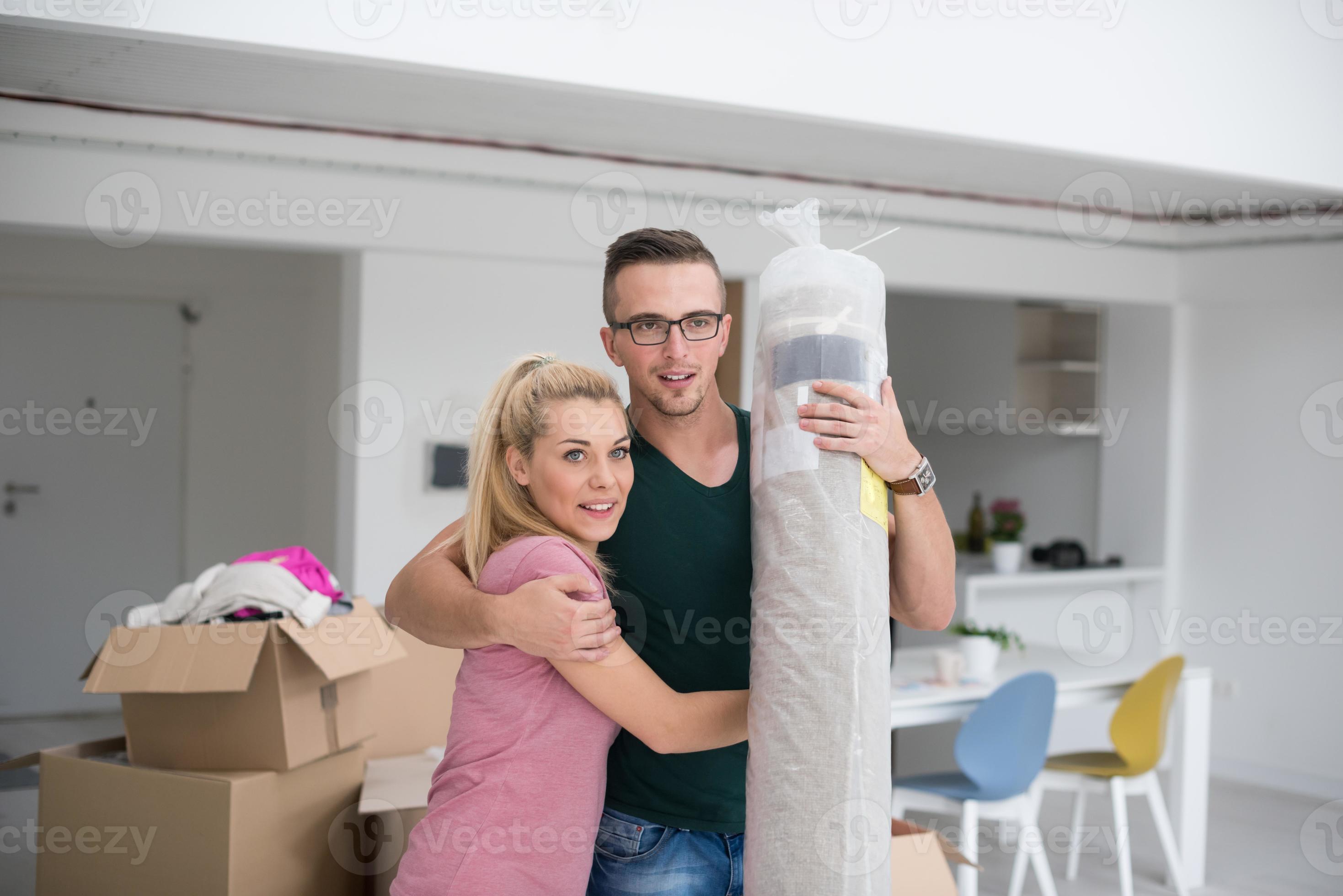 couple carrying a carpet moving in to new home 10979642 Stock Photo at