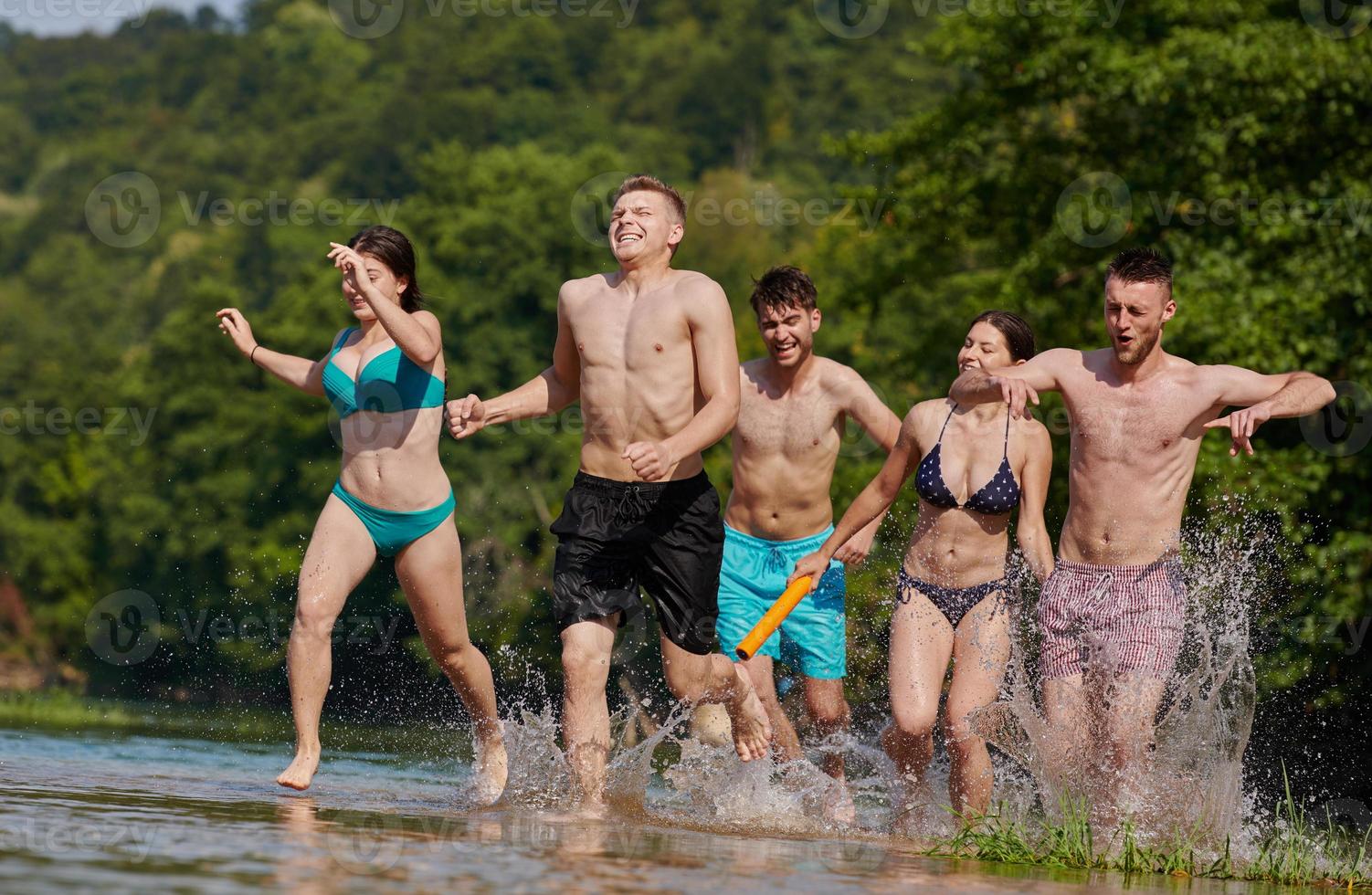 grupo de amigos felices divirtiéndose en el río foto