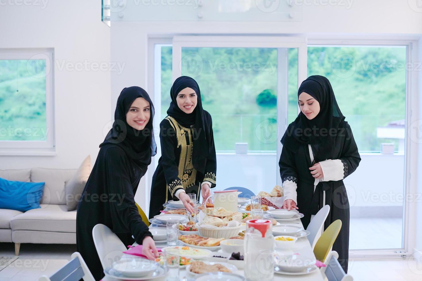 young muslim girls serving food on the table for iftar dinner photo