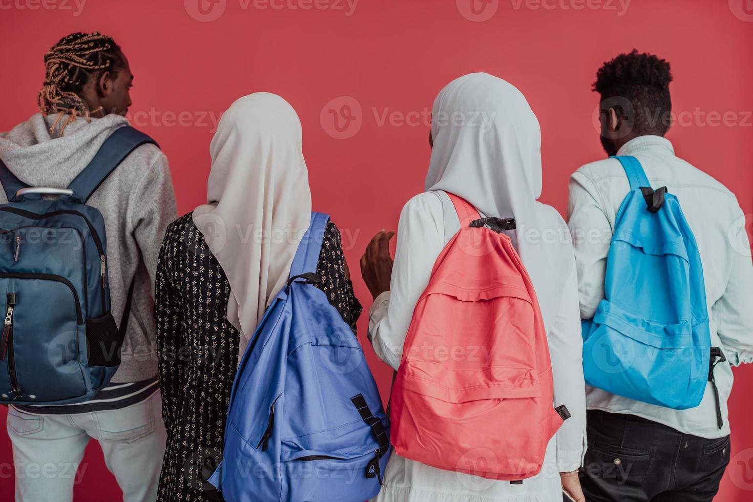 A group of African Muslim students with backpacks posing on a pink background. the concept of school education. photo