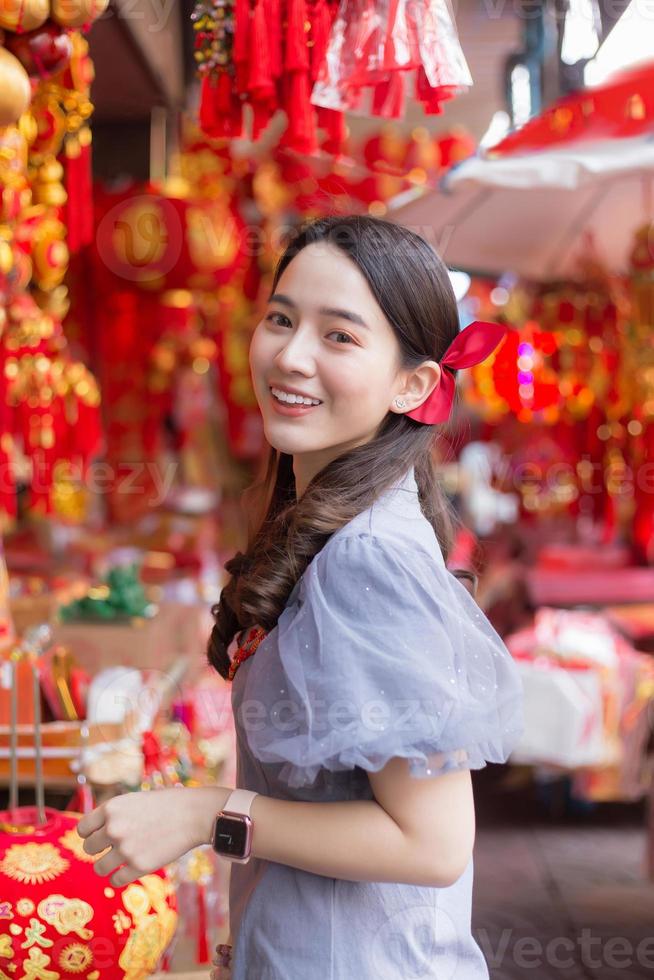 Asian beautiful woman in grey dress smiles in Chinese New Year theme as background. photo