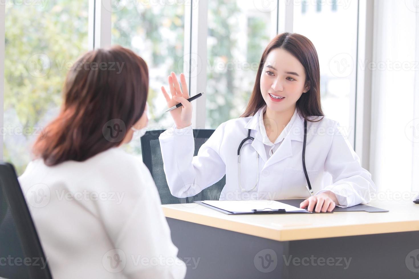 Asian doctor woman who wears medical coat talks with woman patient elderly to suggest treatment guideline and healthcare concept in office photo