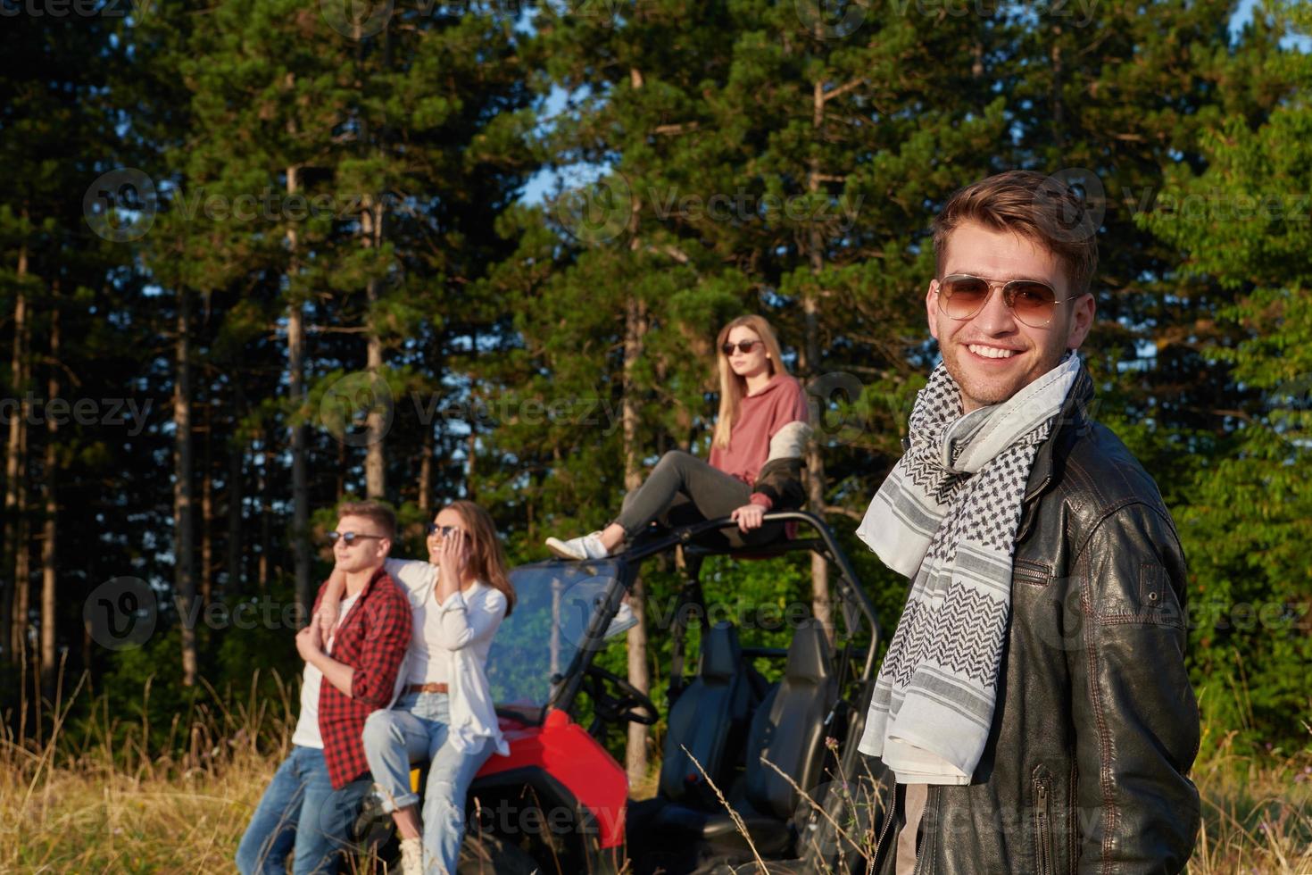 group young happy people enjoying beautiful sunny day while driving a off road buggy car photo