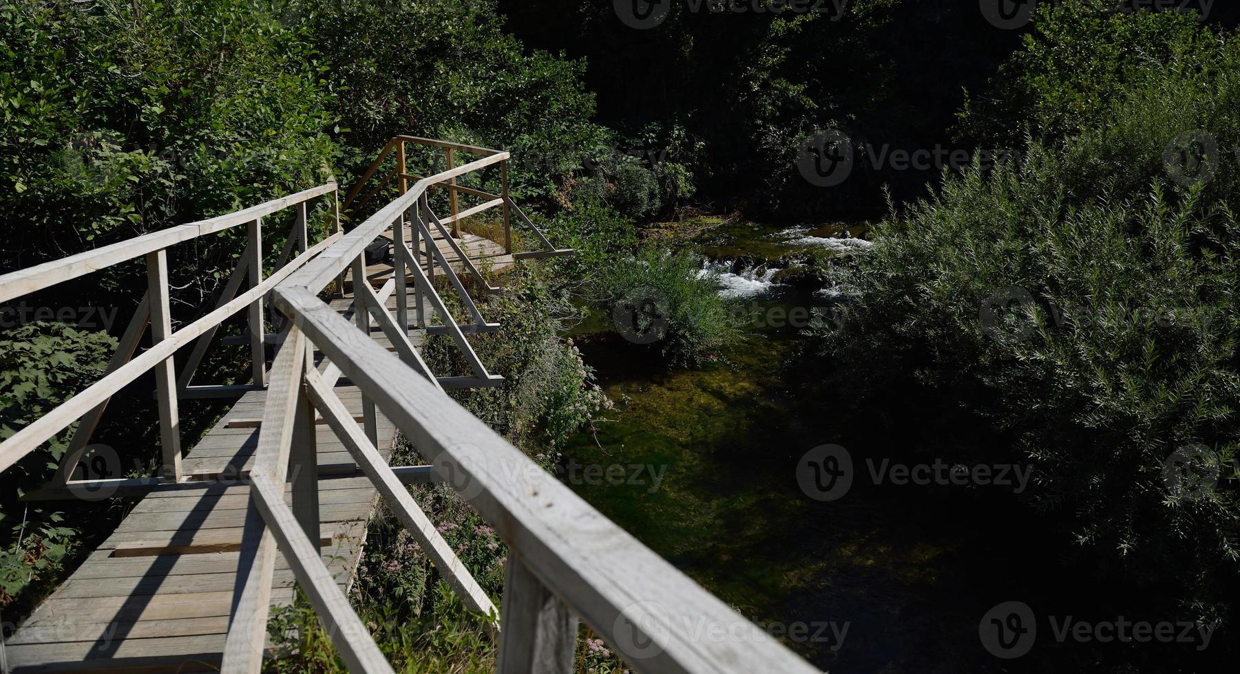 wooden bridge over wild river photo