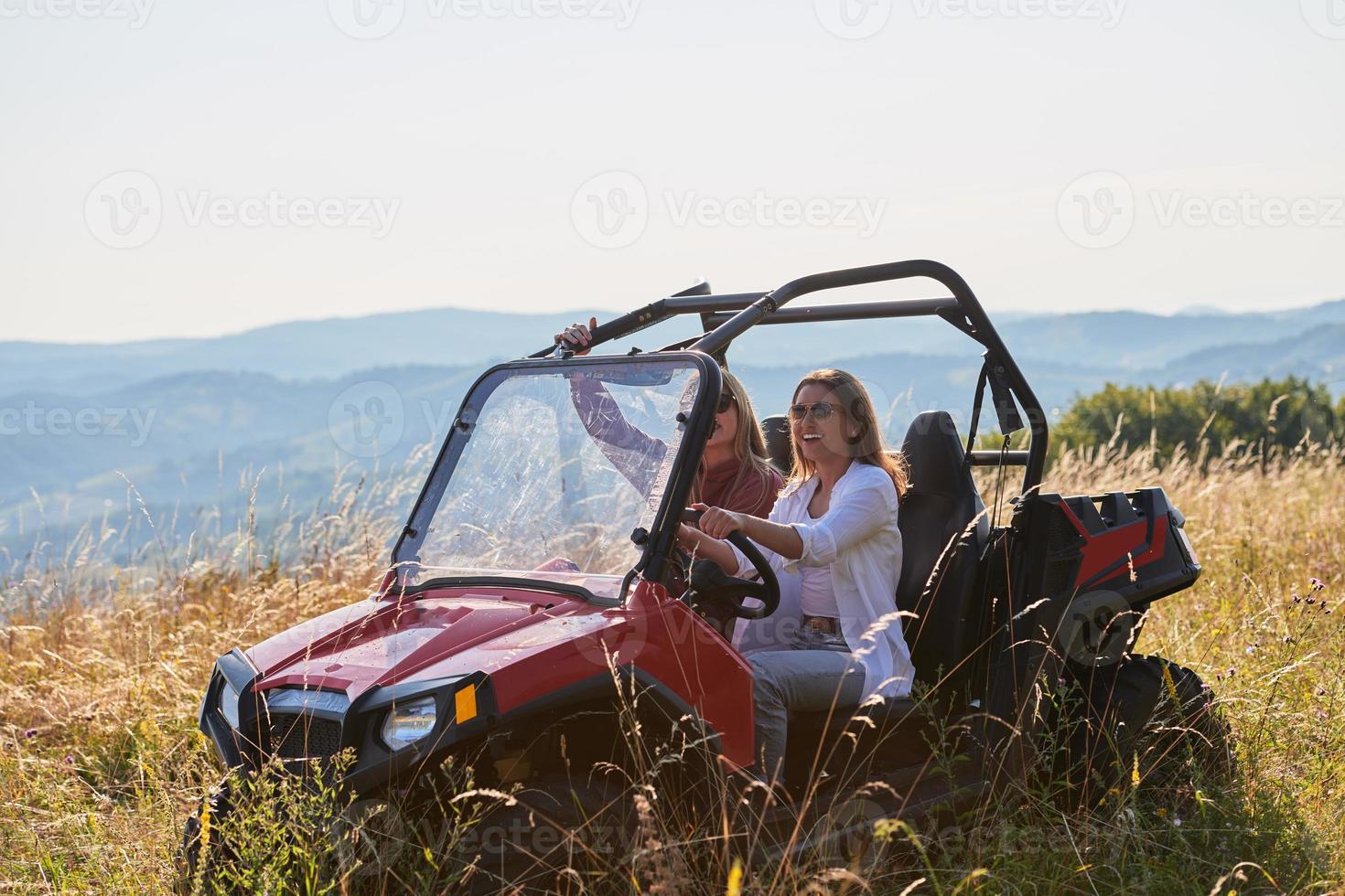 girls enjoying a beautiful sunny day while driving an off-road car photo