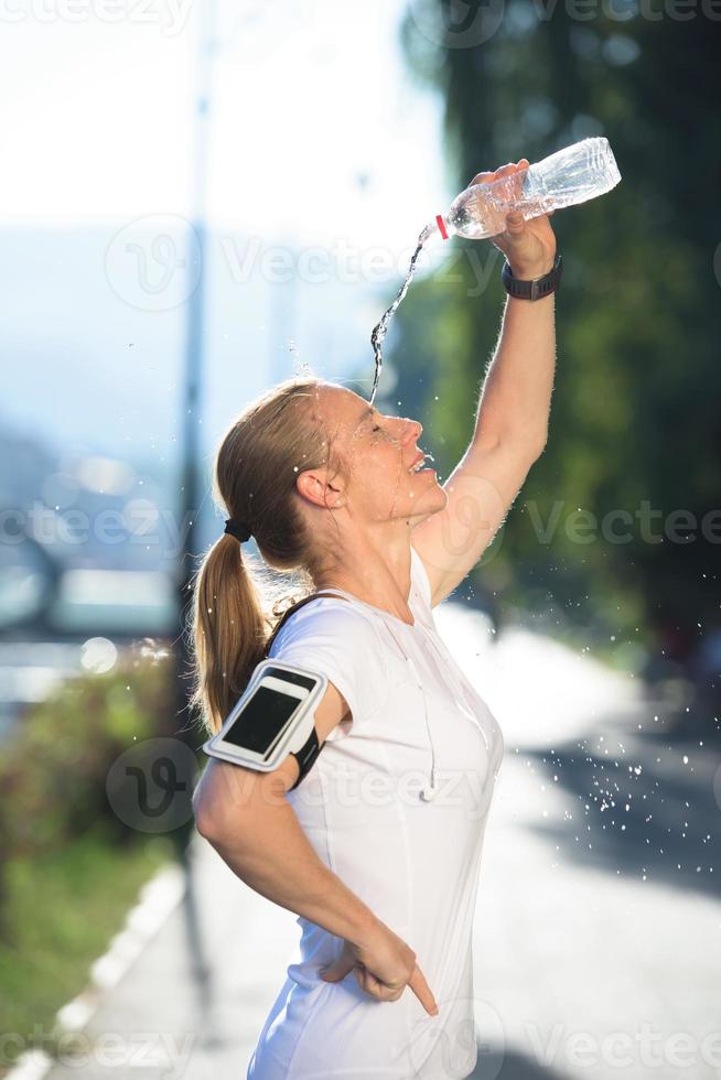 woman drinking  water after  jogging photo