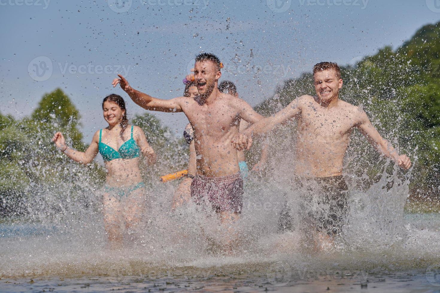 grupo de amigos felices divirtiéndose en el río foto