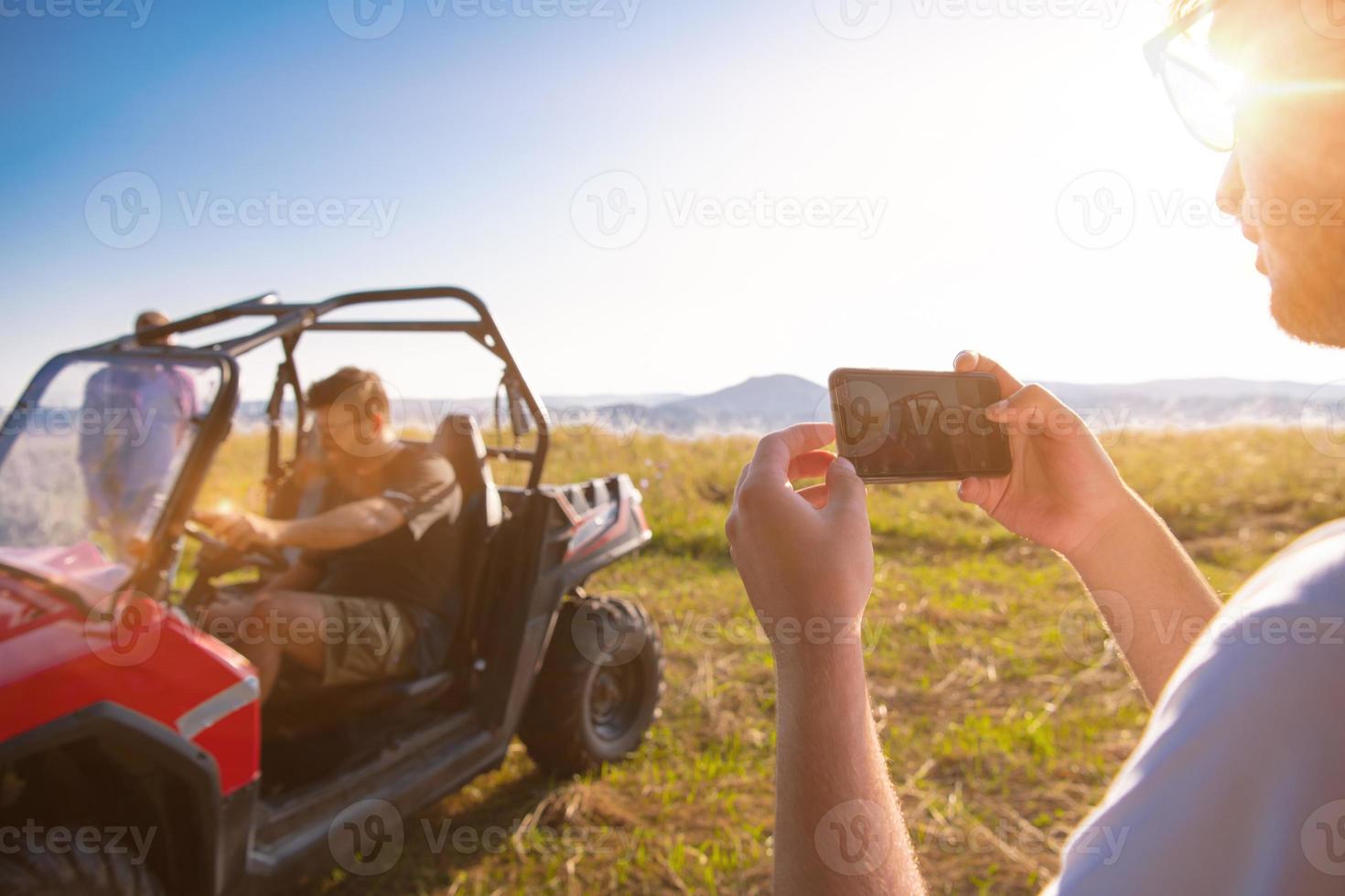 two young men having fun while driving a off road buggy car photo