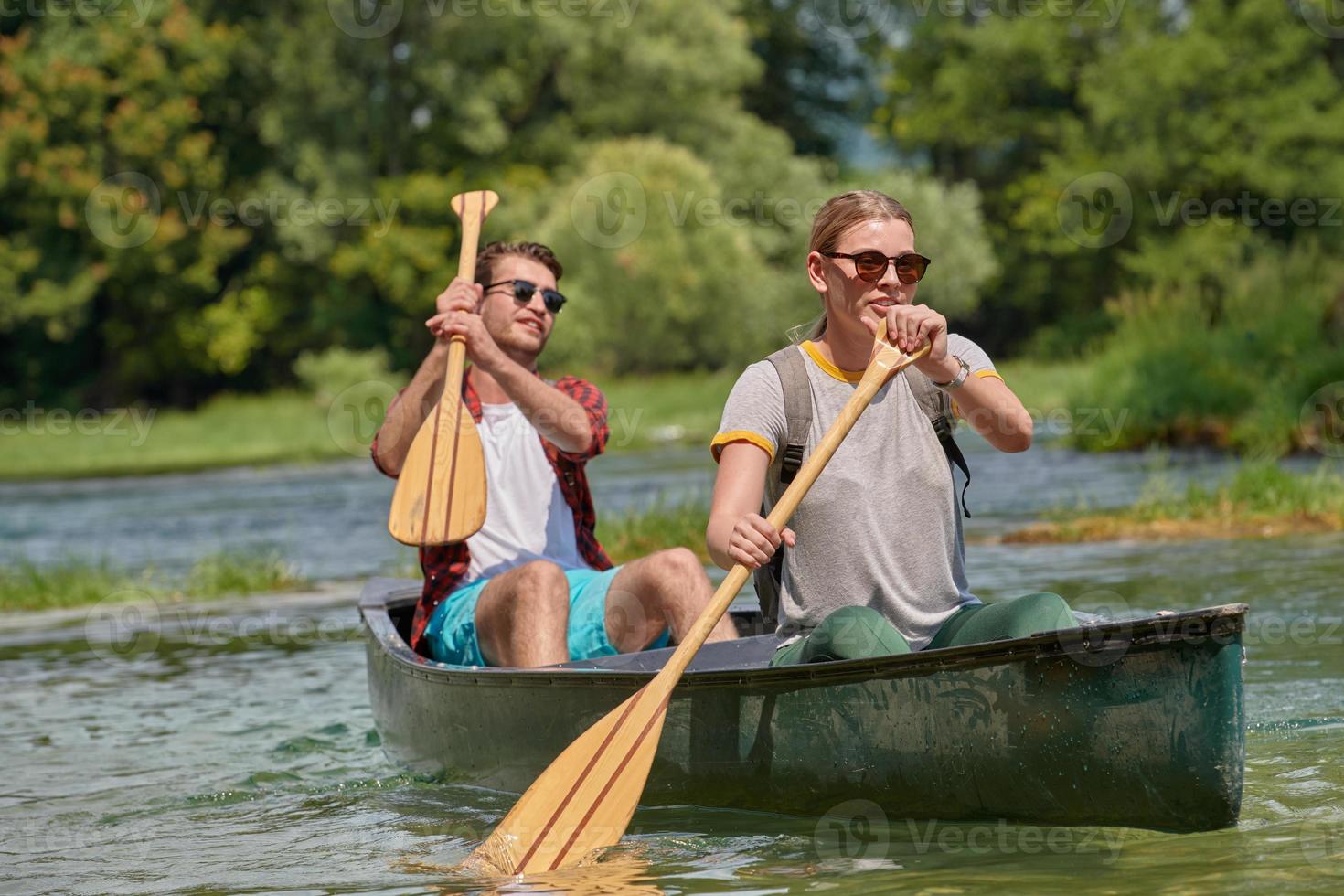 friends are canoeing in a wild river photo