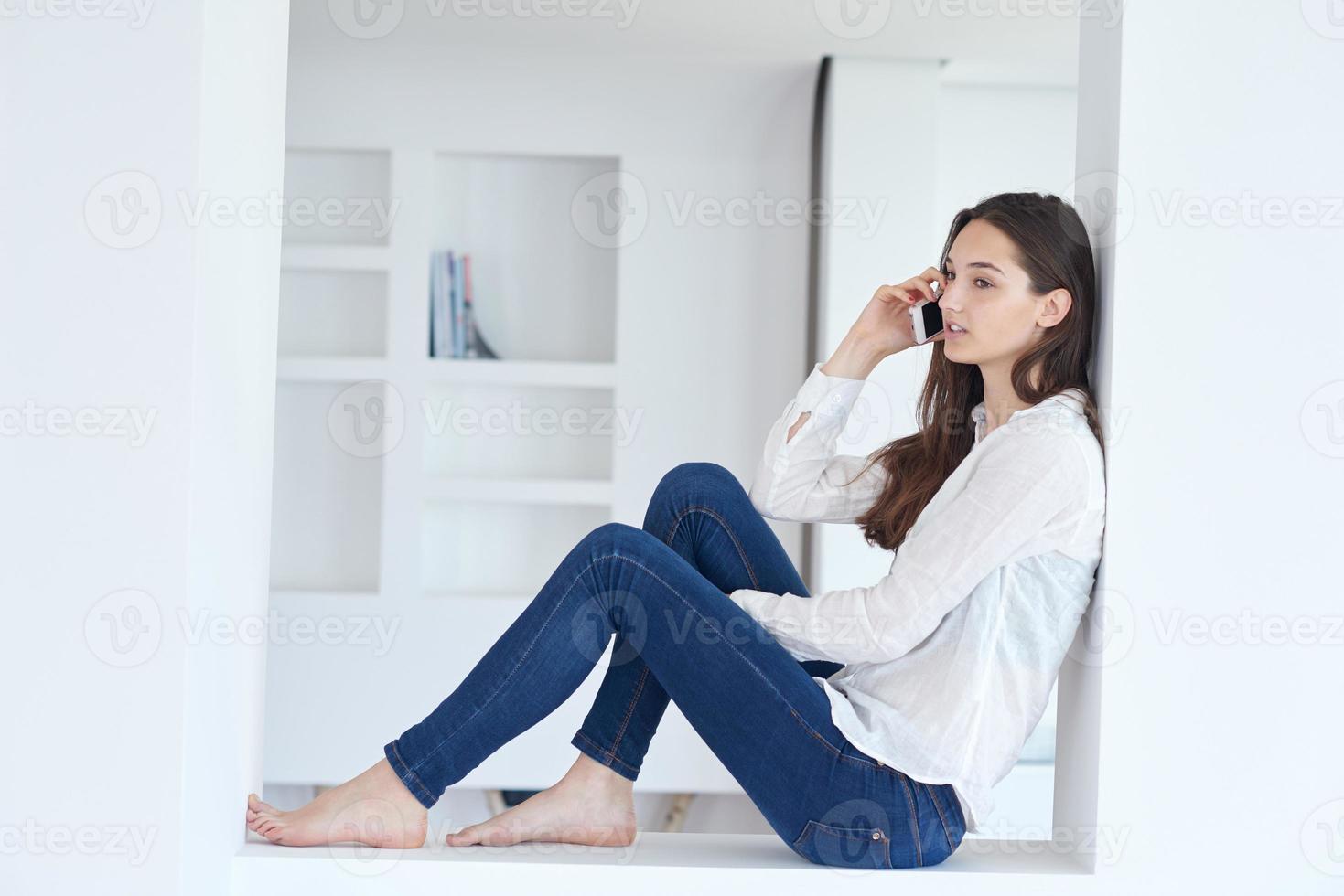 young woman using cellphone at home photo