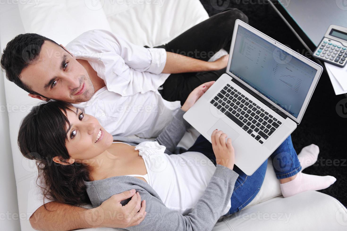 joyful couple relax and work on laptop computer at modern home photo