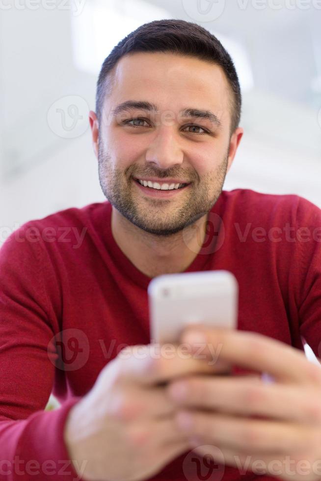 young man using a mobile phone  at home photo