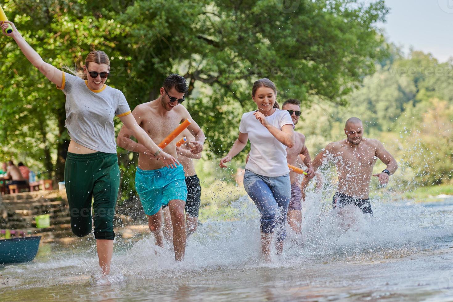 grupo de amigos felices divirtiéndose en el río foto