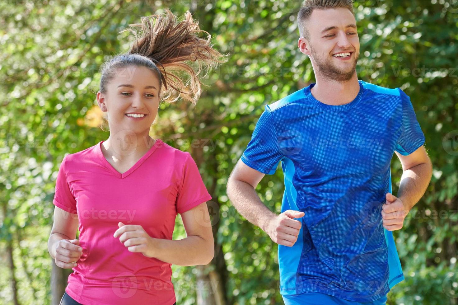 couple enjoying in a healthy lifestyle while jogging on a country road photo