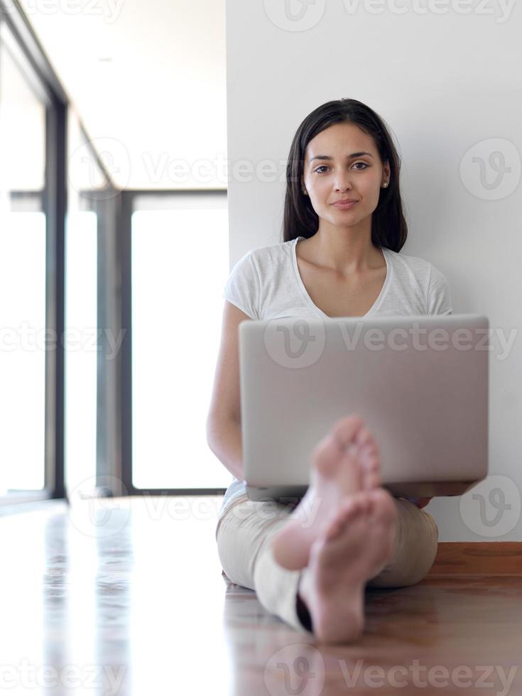 relaxed young woman at home working on laptop computer photo