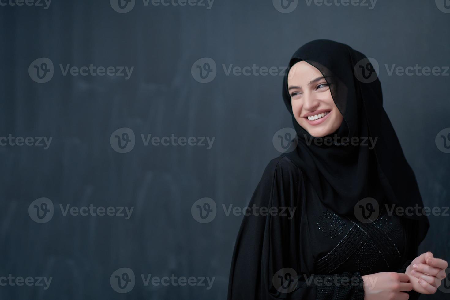 Modern young muslim woman in black abaya photo