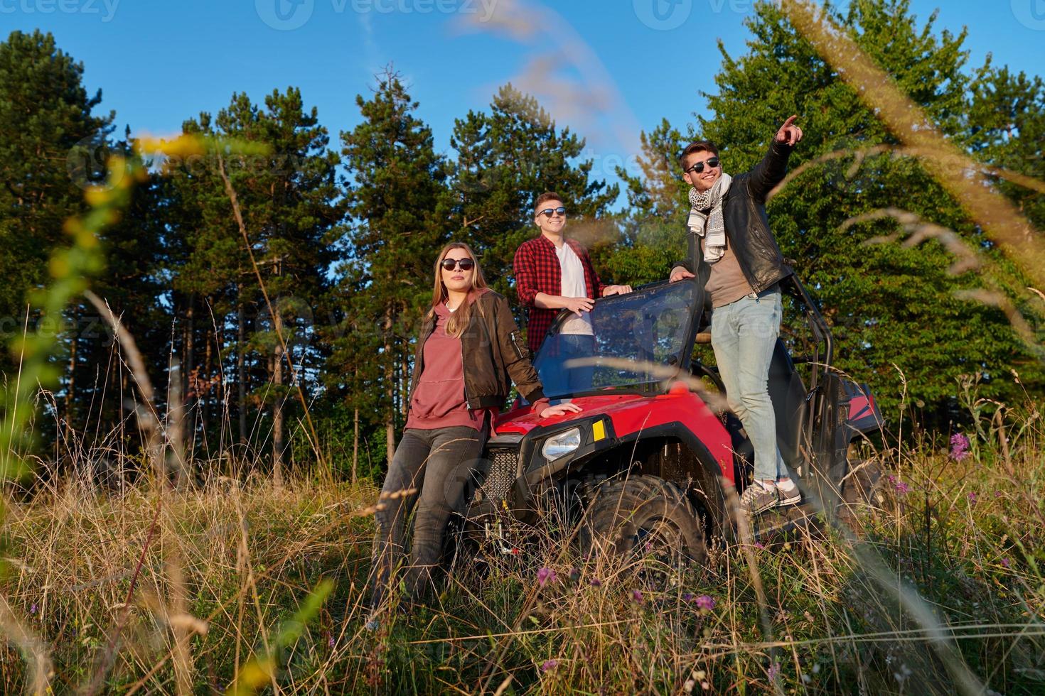 group young happy people enjoying beautiful sunny day while driving a off road buggy car photo