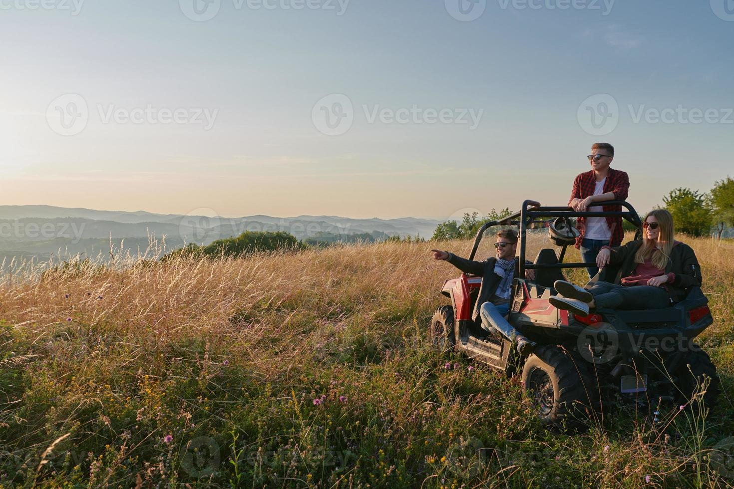 group young happy people enjoying beautiful sunny day while driving a off road buggy car photo