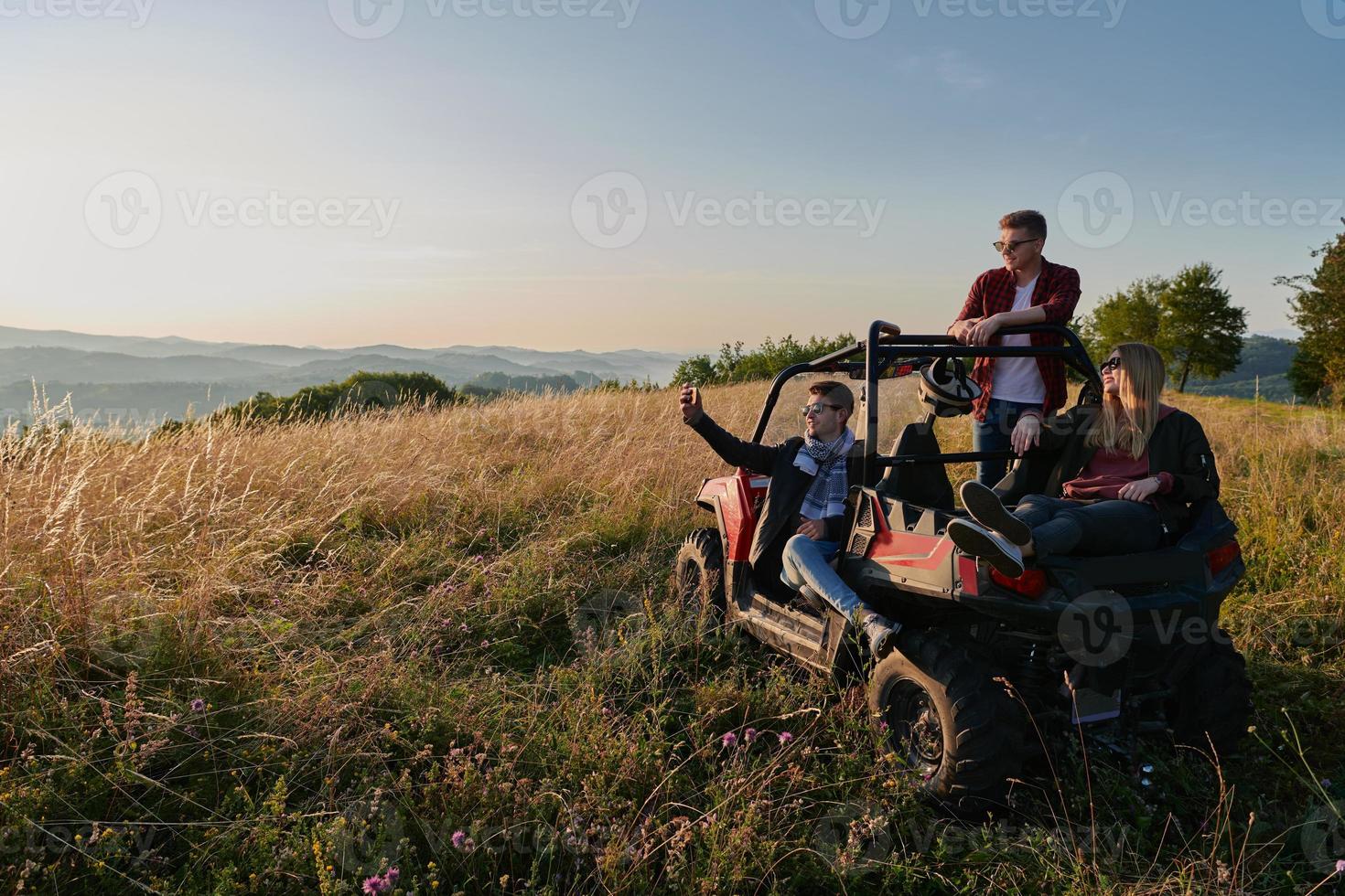 group young happy people enjoying beautiful sunny day while driving a off road buggy car photo